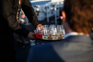 Waiter holding champagne tray showing bar options on Anita Dee Chicago private yacht charter.