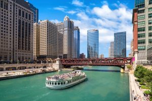 Anita Dee Yacht Charter sailing down a cerulean Chicago River towards a metal bridge.