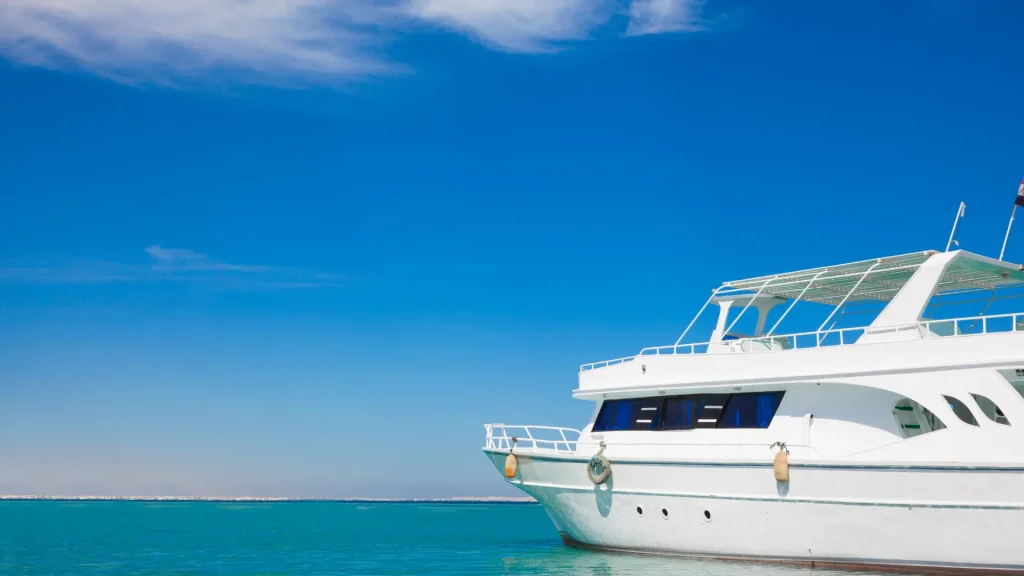 A luxurious white yacht floating on calm turquoise waters under a bright blue sky, evoking a sense of leisure and travel.