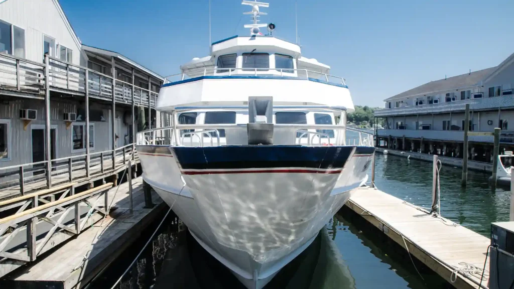 A large yacht docked at the marina, viewed from the front.